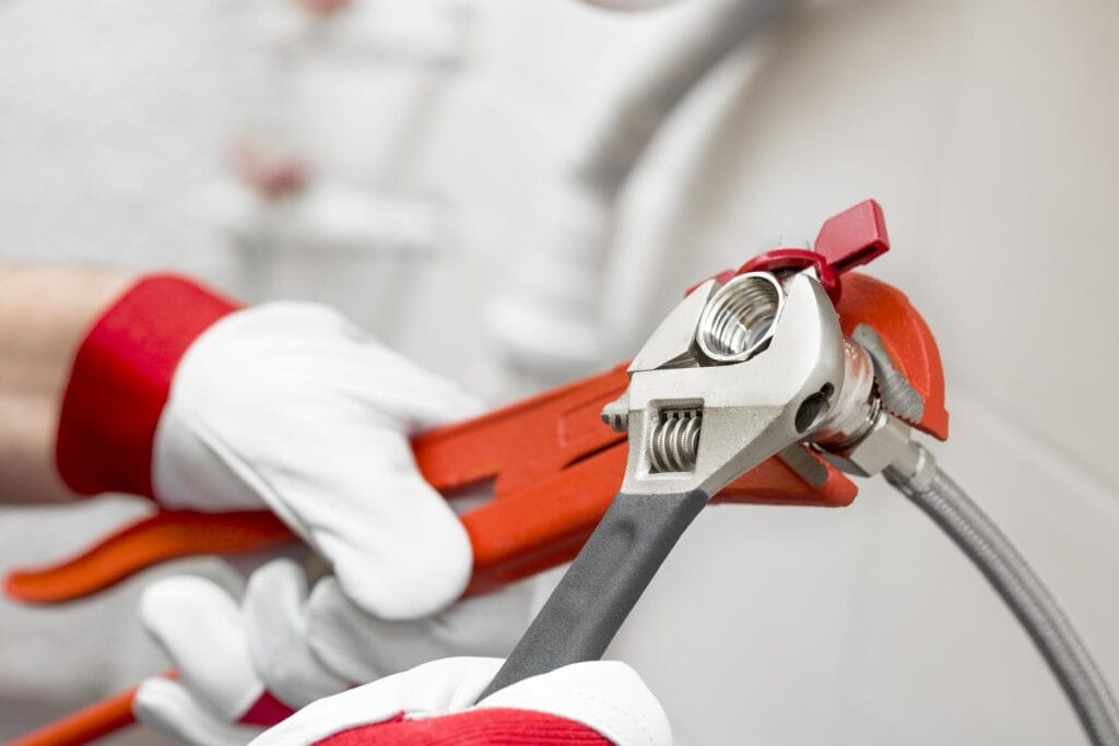 Plumber holding pipe wrenches for an emergency repair in Kissimmee
