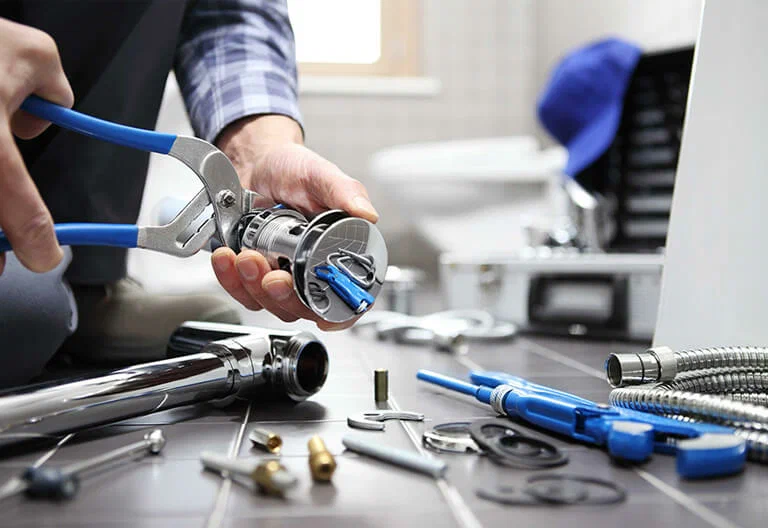 Technician repairing a plumbing fixture with professional tools in Kissimmee