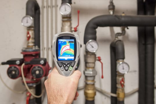Plumber using a thermal imaging camera to inspect pipes in Kissimmee