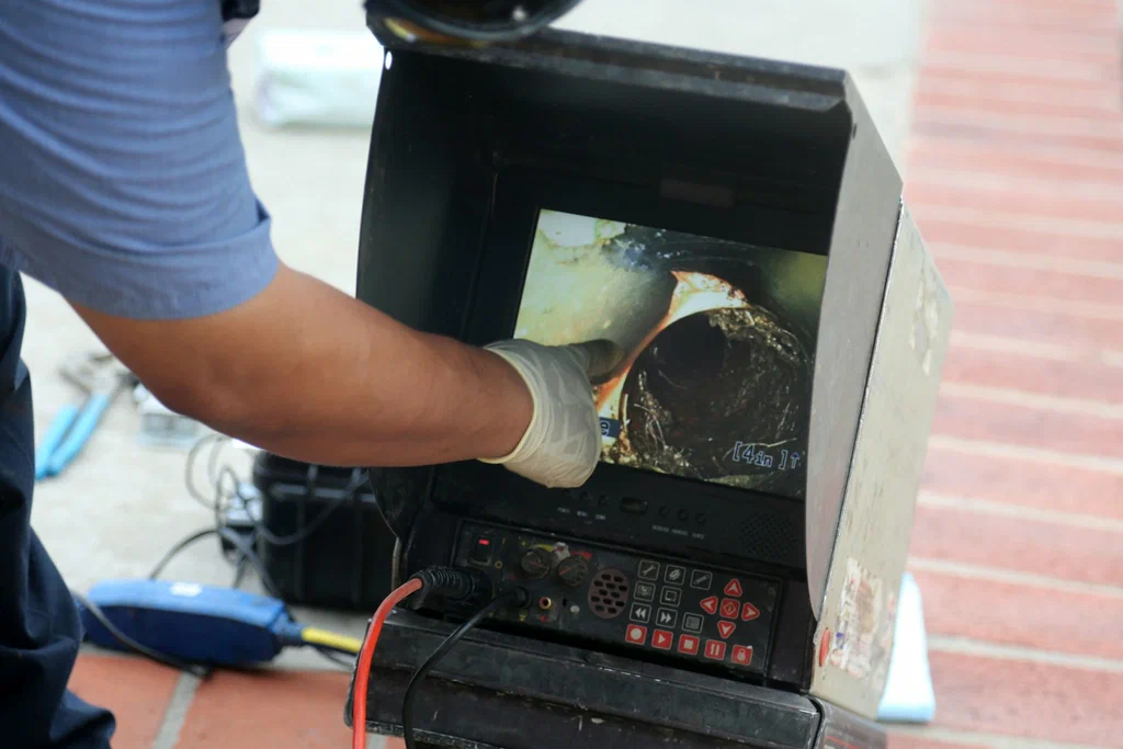 Technician viewing a drain inspection camera in Kissimmee