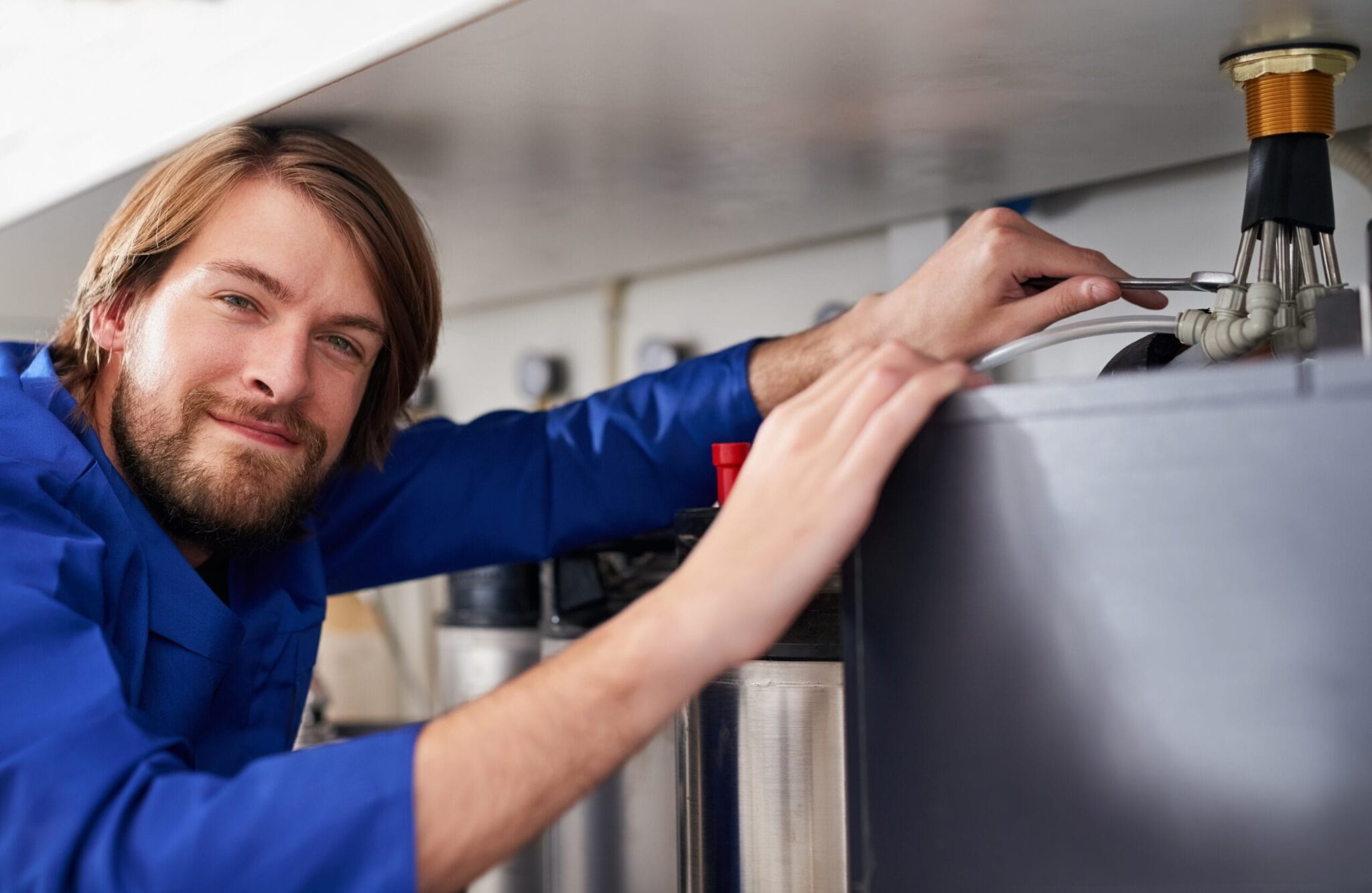 Technician servicing a residential water heater tank in Kissimmee