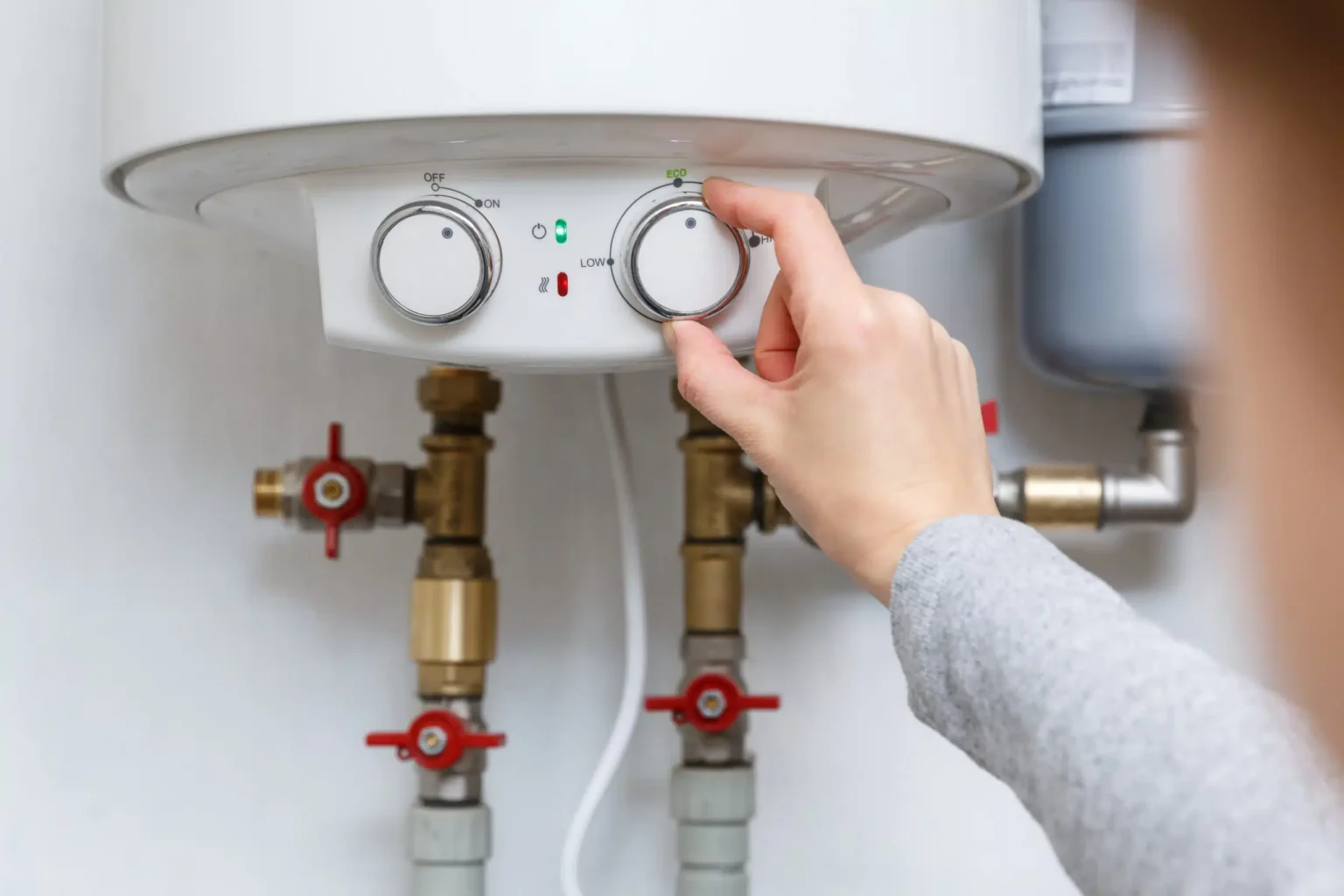 Homeowner adjusting the temperature controls on a water heater in Kissimmee